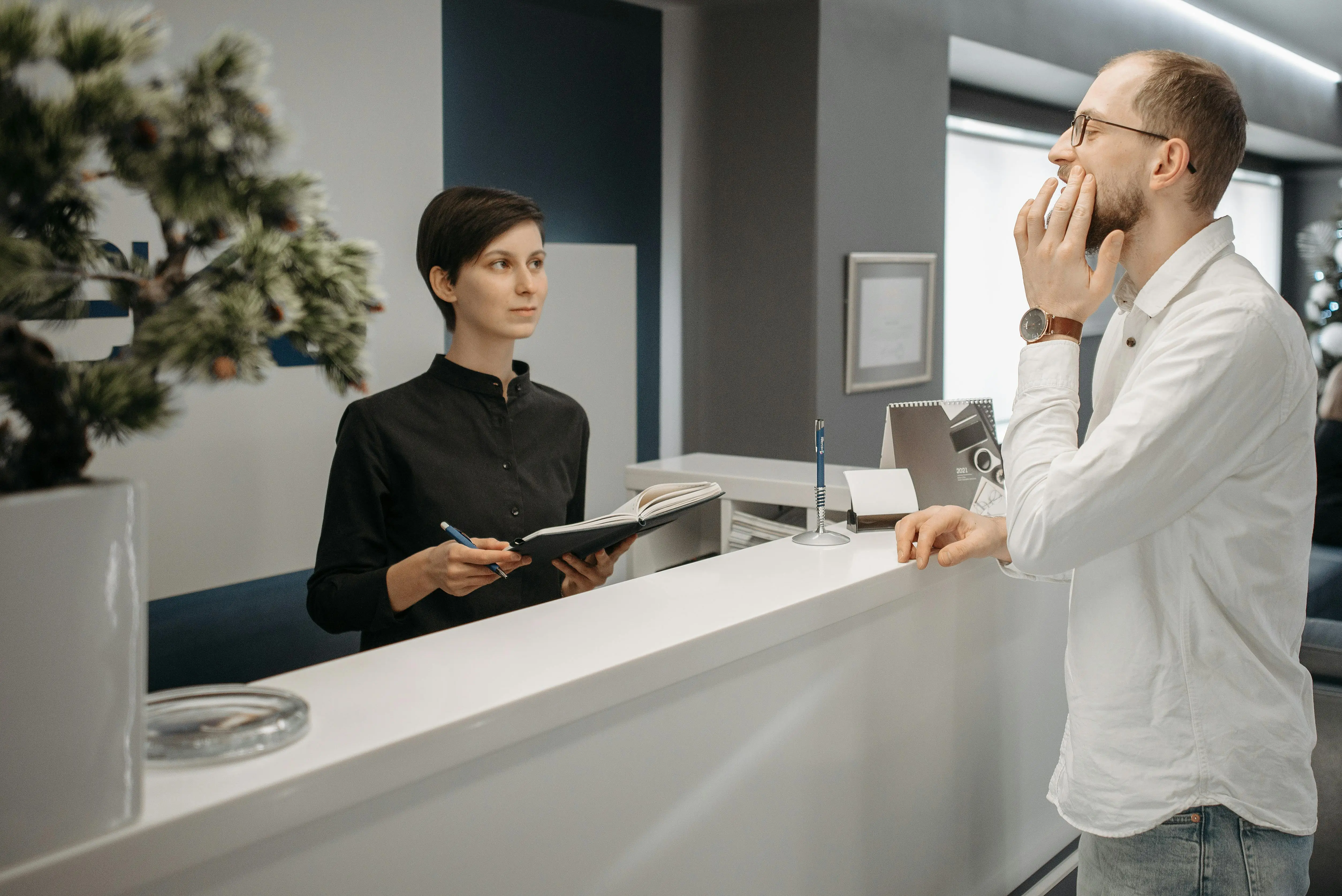 Patient speaking with reception at a modern dental clinic